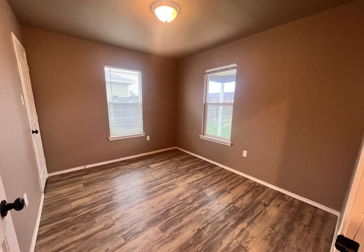 1516 East 8th Street Lubbock, TX 79403 - Photo 5 of 7 an empty room with wooden floor and windows