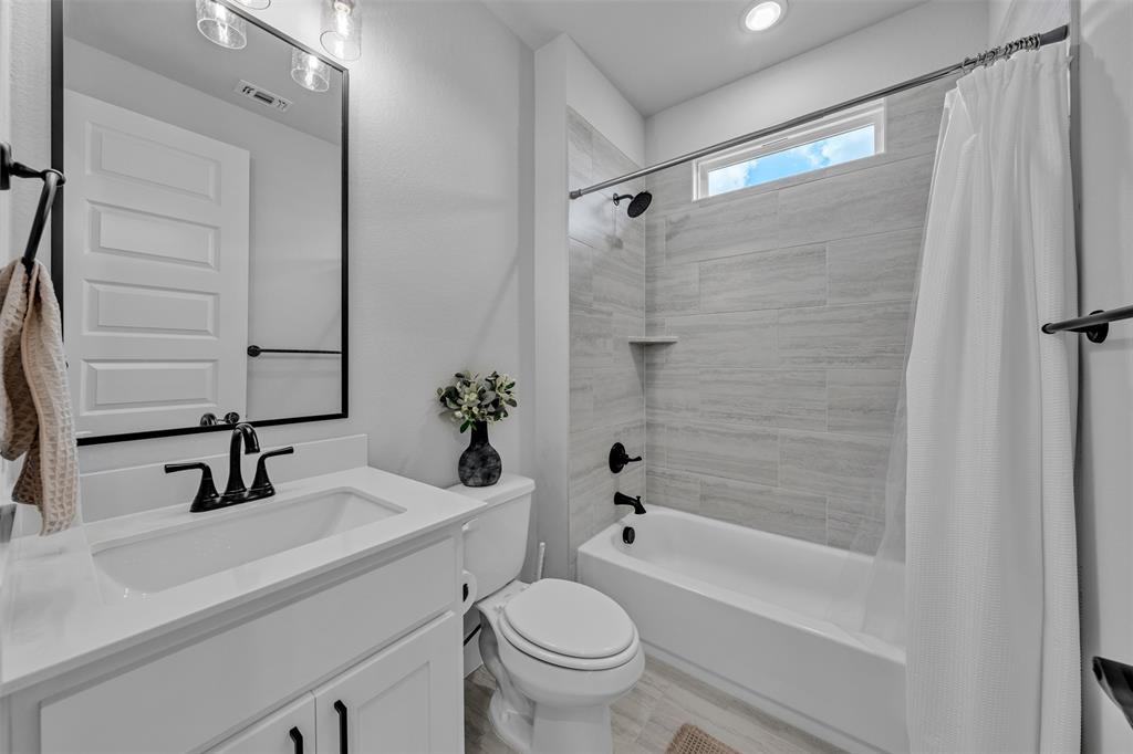 2004 Willy Dilly Road Springtown, TX 76082 - Photo 21 of 40 Full bathroom featuring a white vanity with integrated sink, black plumbing fixtures, and a shower-tub combination with light-toned tiled walls