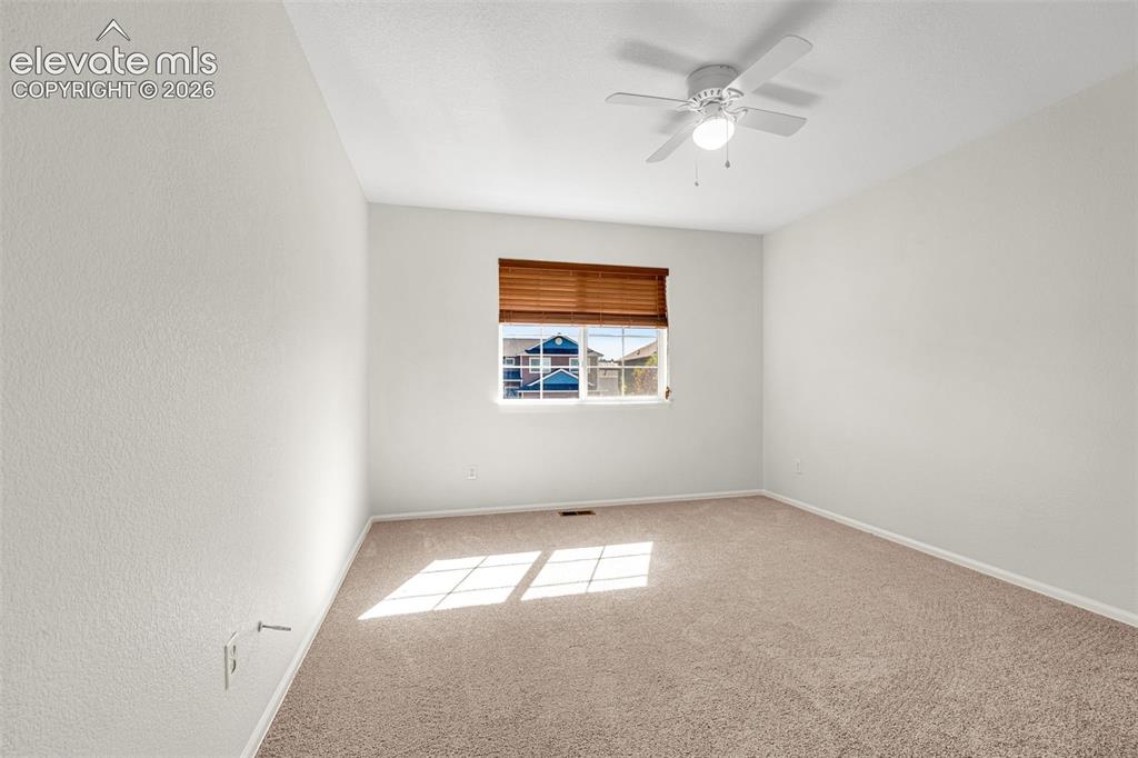 11185 Falling Star Road Fountain, CO 80817 - Photo 19 of 46 an empty room with windows and fan