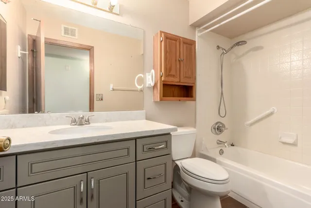 a bathroom with a granite countertop sink toilet and shower