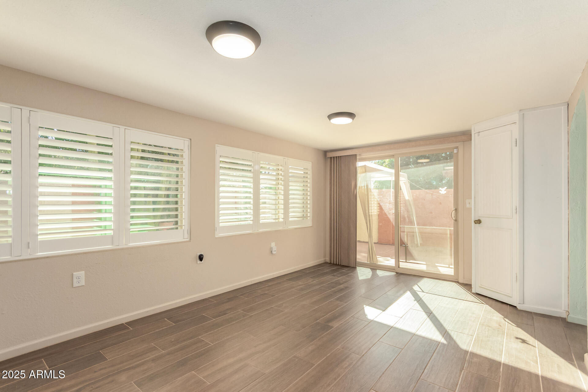 542 South Higley Road, Unit 3 Mesa, AZ 85206 - Photo 8 of 33 a view of an empty room with wooden floor and a window