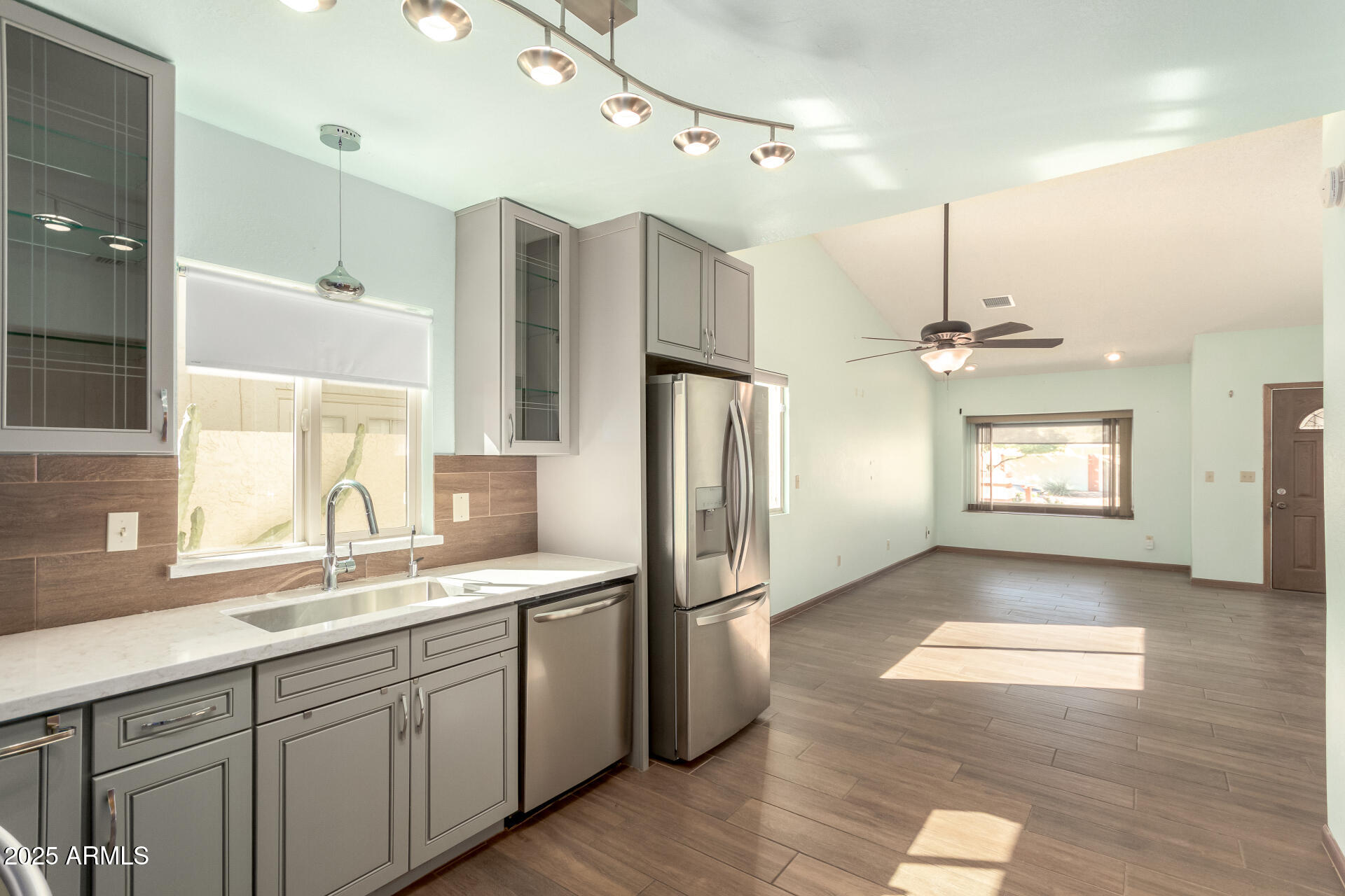 542 South Higley Road, Unit 3 Mesa, AZ 85206 - Photo 9 of 33 a kitchen with stainless steel appliances granite countertop a refrigerator a sink dishwasher and white cabinets with wooden floor