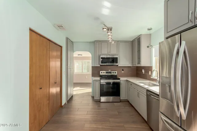 a kitchen with stainless steel appliances granite countertop a refrigerator stove and sink