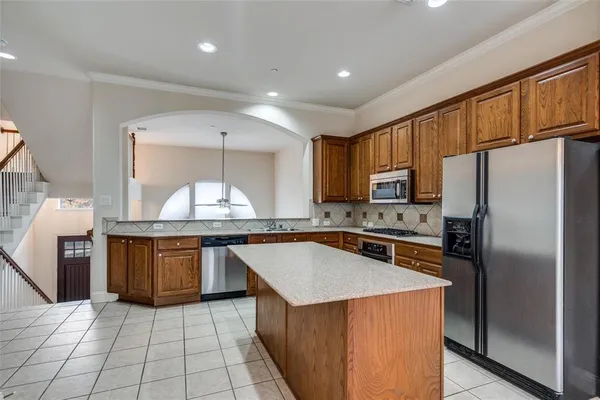 a kitchen with granite countertop a stove refrigerator and cabinets