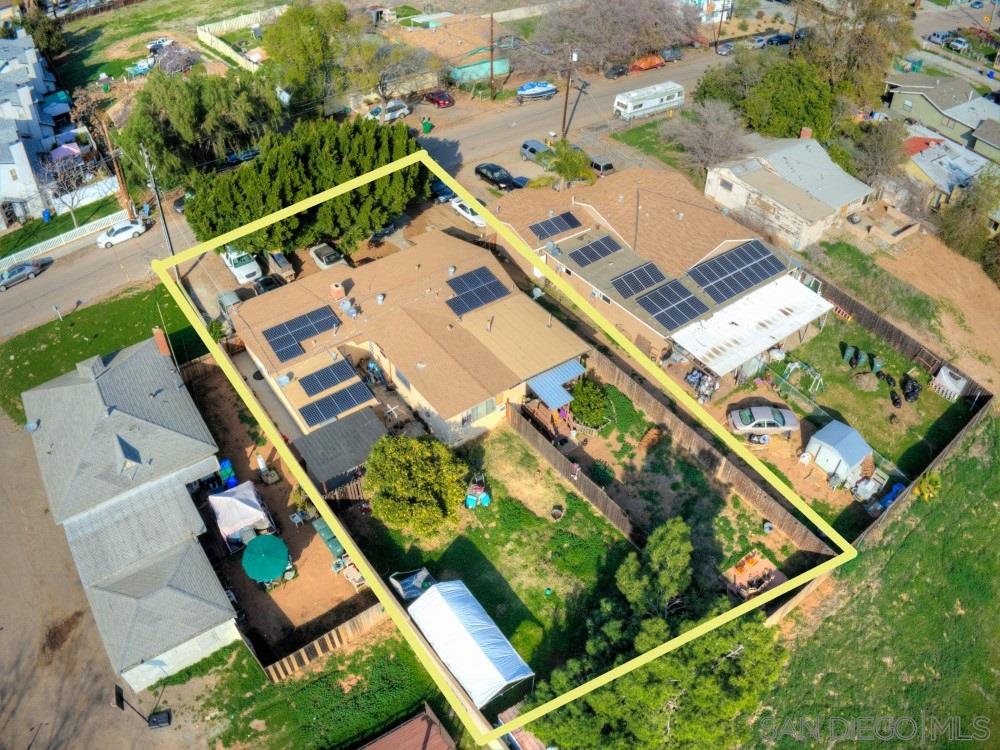 an aerial view of a tennis ground and a cars park side of the road