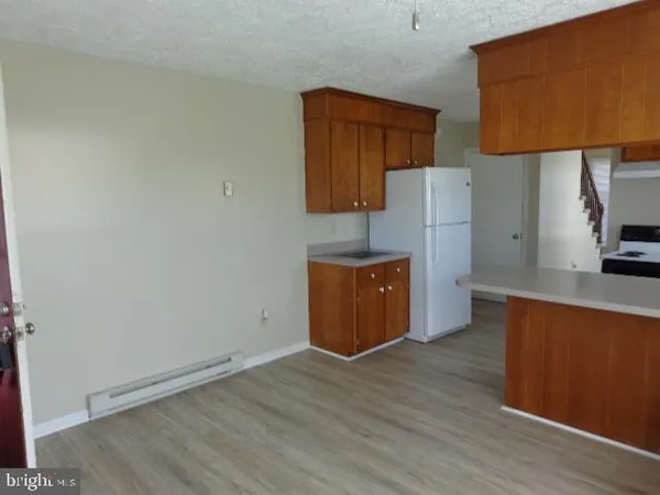 an empty room with wooden floor and cabinet