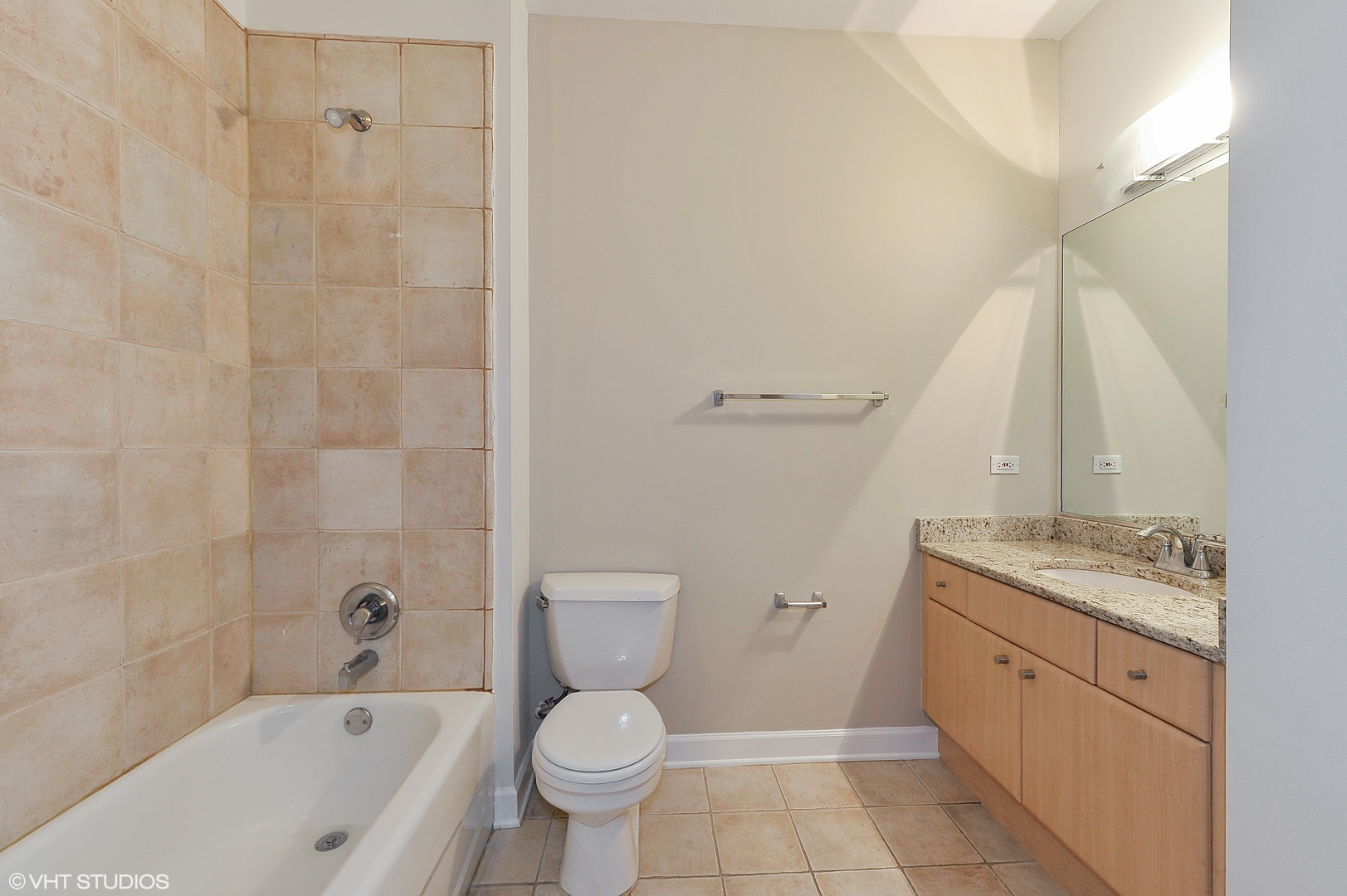 1301 West Madison Street, Unit 506 Chicago, IL 60607 - Photo 14 of 23 a bathroom with a granite countertop toilet a sink and a bathtub