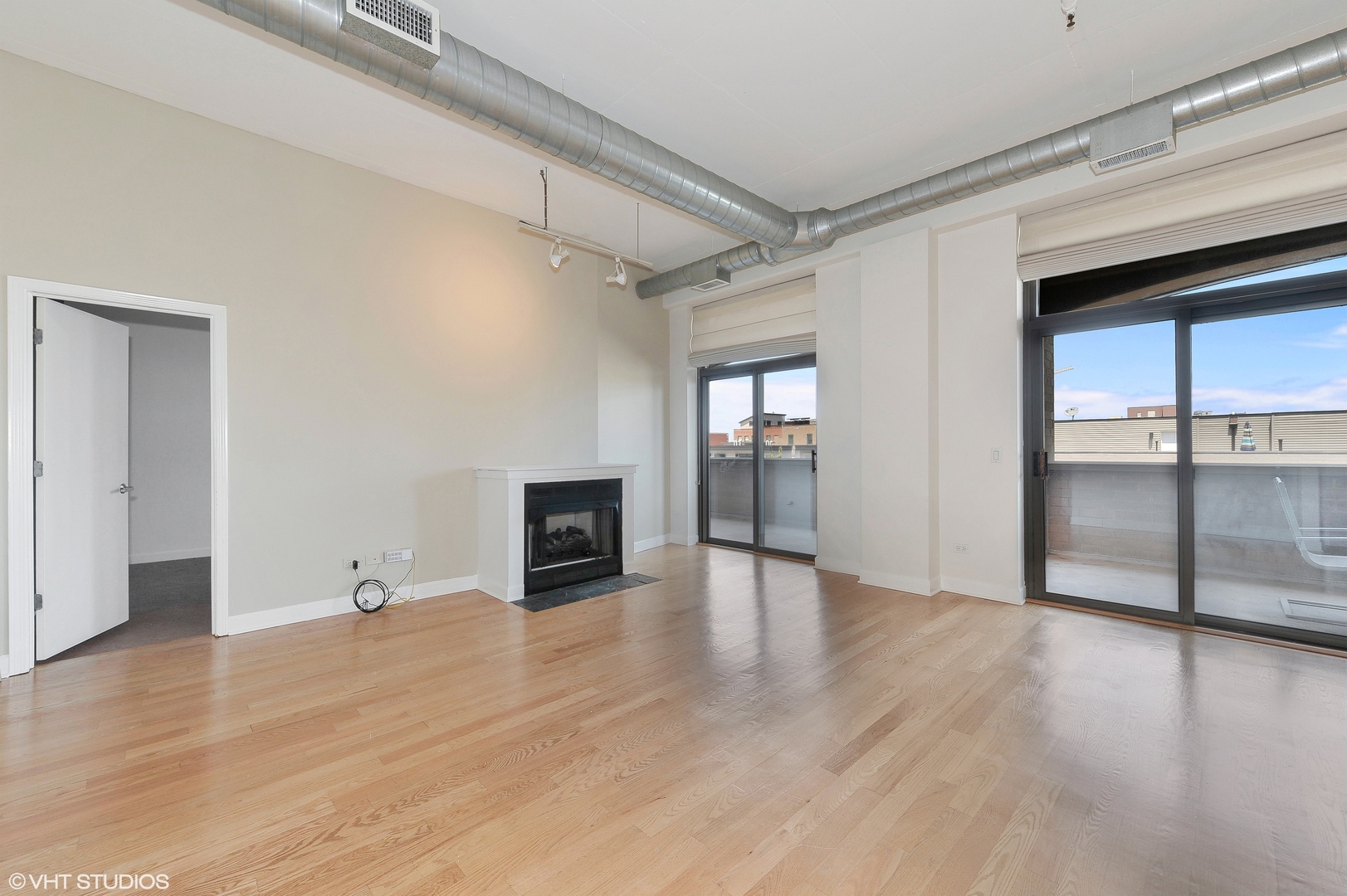 1301 West Madison Street, Unit 506 Chicago, IL 60607 - Photo 2 of 23 a view of empty room with wooden floor and fireplace