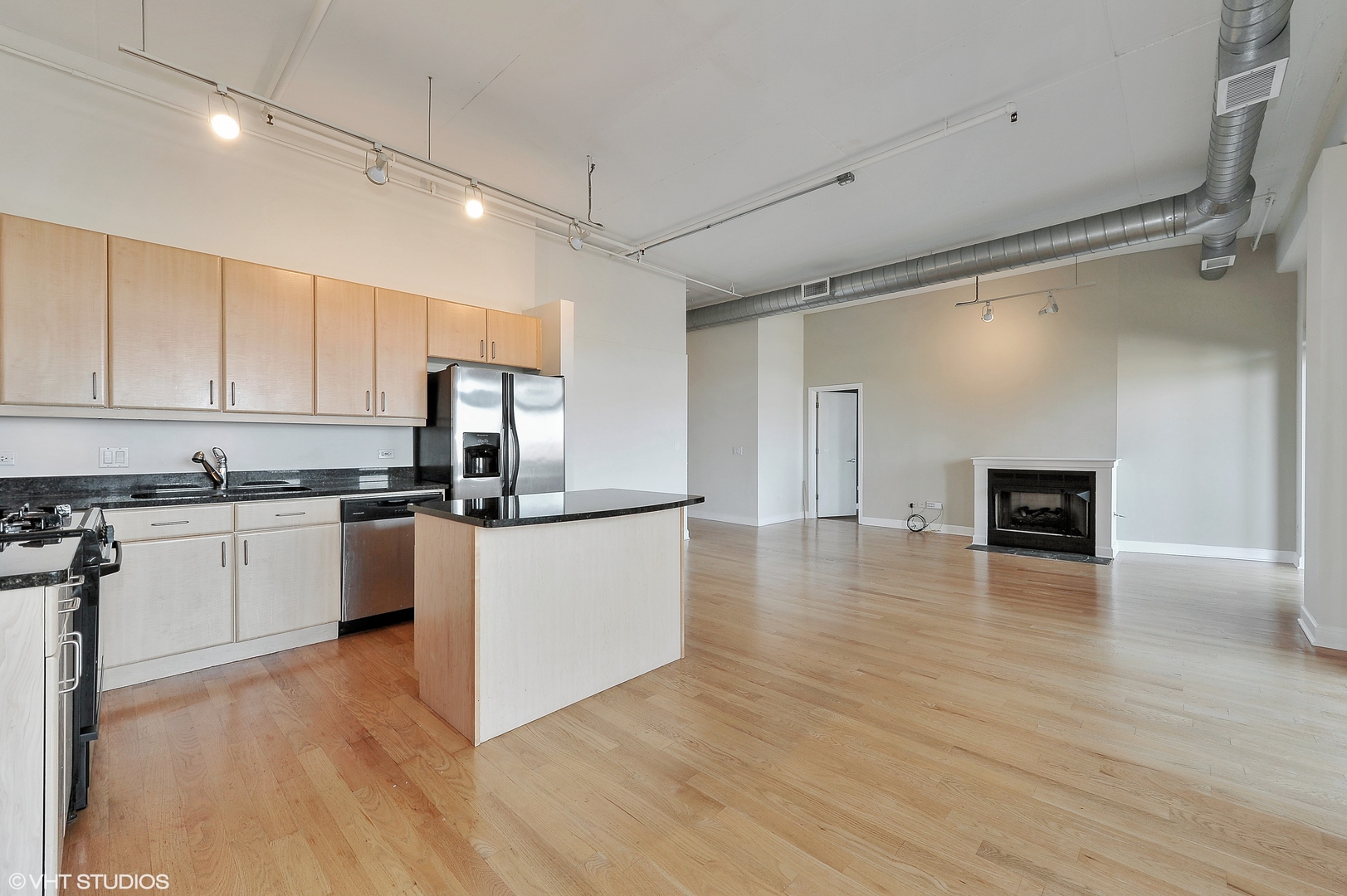 1301 West Madison Street, Unit 506 Chicago, IL 60607 - Photo 5 of 23 a kitchen with granite countertop a stove top oven a sink dishwasher and a refrigerator with wooden floor