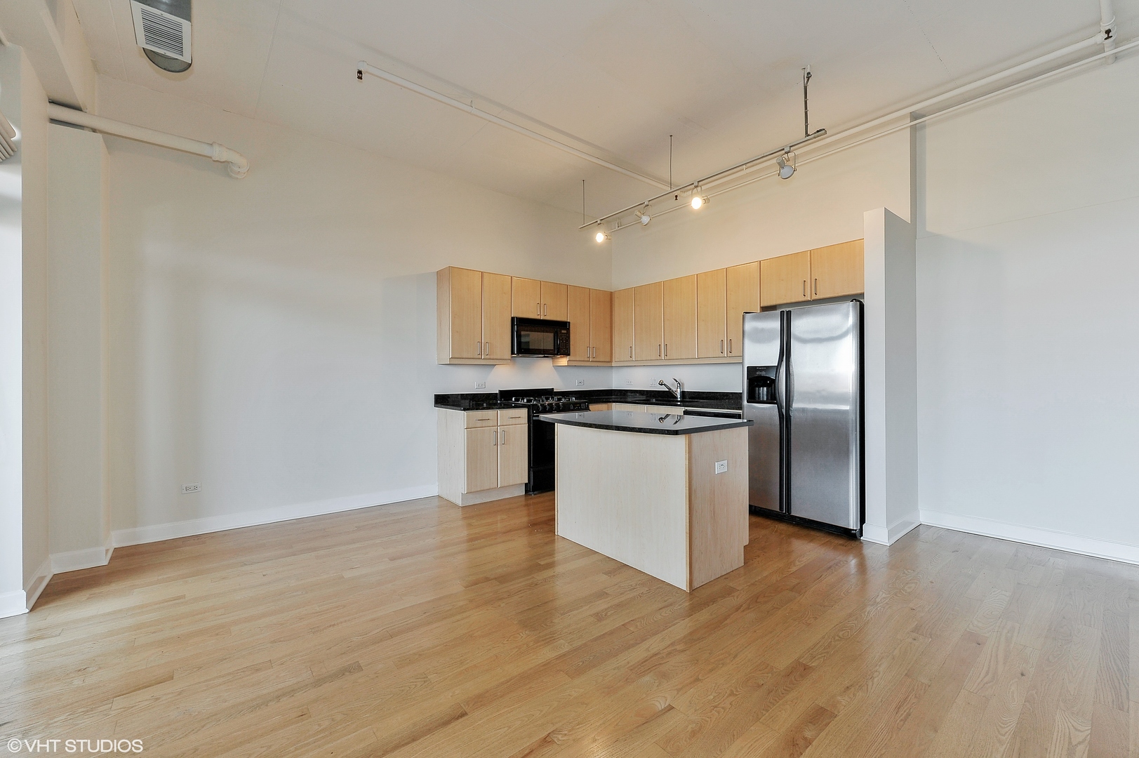 1301 West Madison Street, Unit 506 Chicago, IL 60607 - Photo 7 of 23 a kitchen with stainless steel appliances a refrigerator and wooden floor