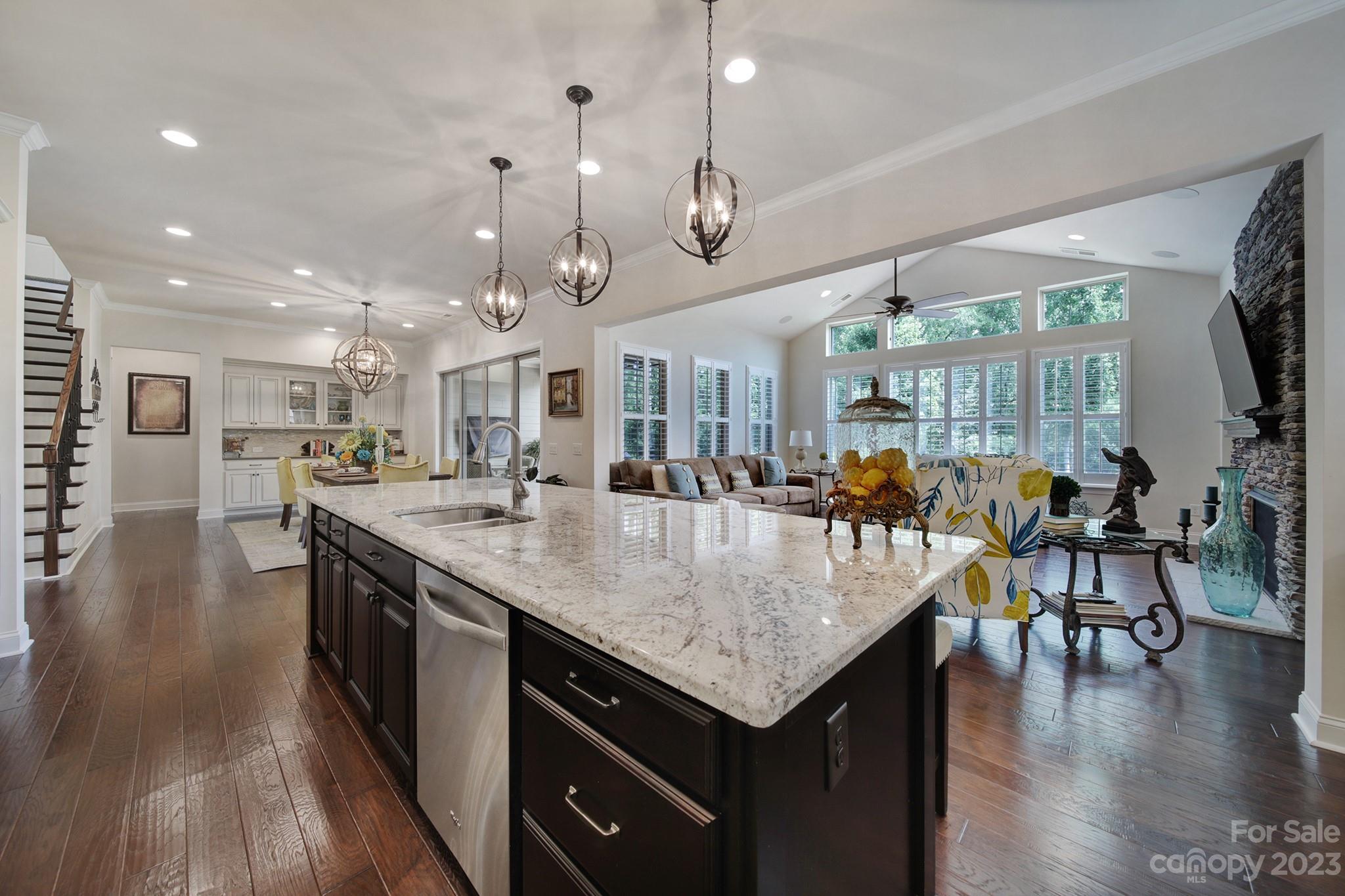 1356 Afton Way Fort Mill, SC 29708 - Photo 16 of 46 an open kitchen with granite countertop a table chairs stove and wooden floor