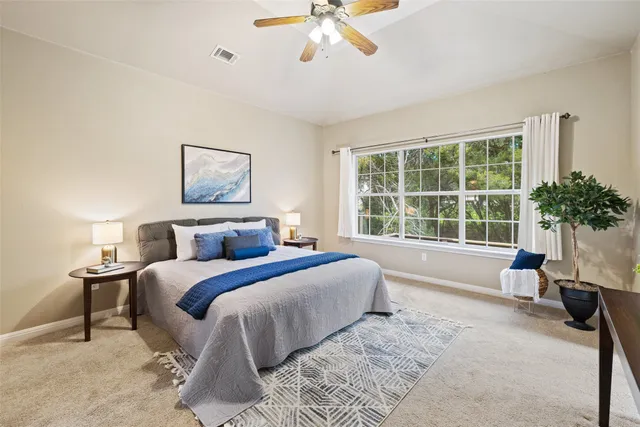 a spacious bedroom with a large bed and a large window