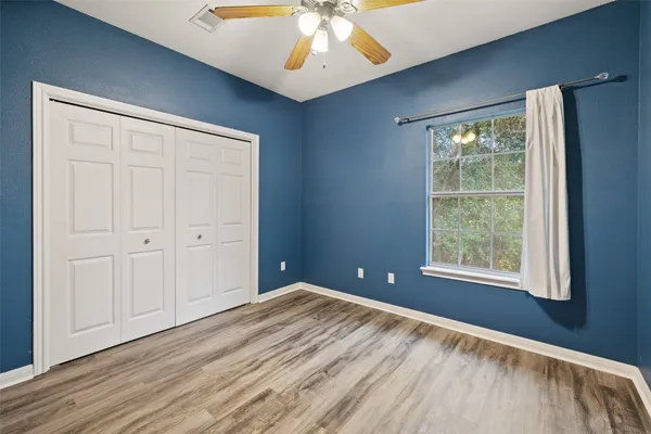a view of an empty room with a window and wooden floor