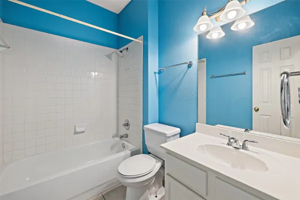 a bathroom with a granite countertop sink toilet a mirror and shower
