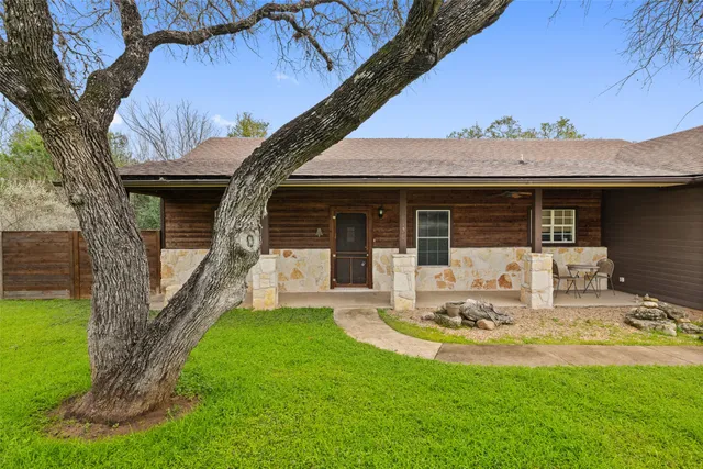 a view of a house with backyard and sitting area