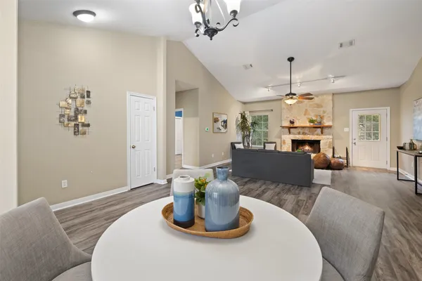 a living room with furniture kitchen view and a chandelier