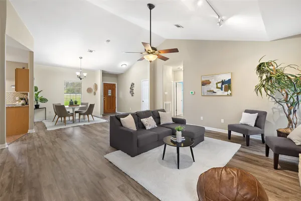 a living room with furniture a chandelier and a dining table