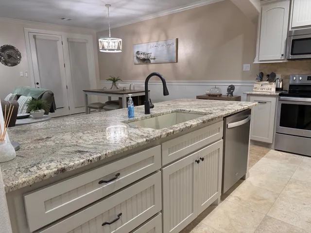 a kitchen with granite countertop white cabinets and appliances