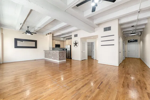 a view of empty room with wooden floor