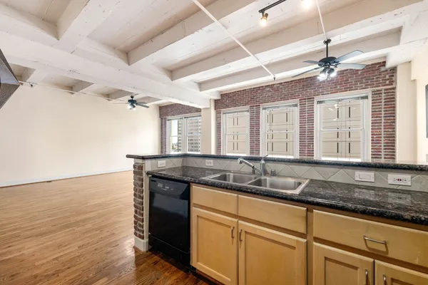 a bathroom with a granite countertop sink a mirror and a shower