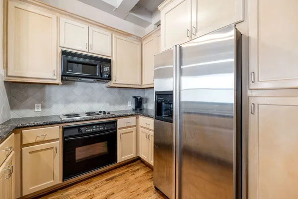 a kitchen with stainless steel appliances granite countertop white cabinets and a granite counter top