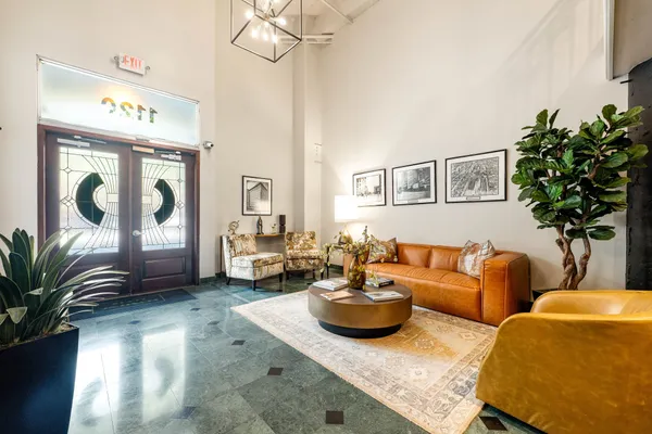 a living room with furniture flowerpot and wooden floor