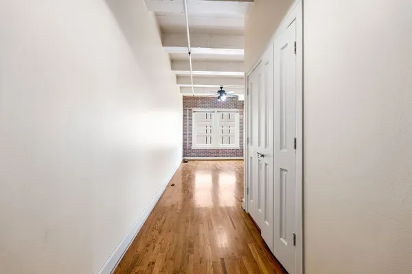 a view of a hallway with wooden floor and a window