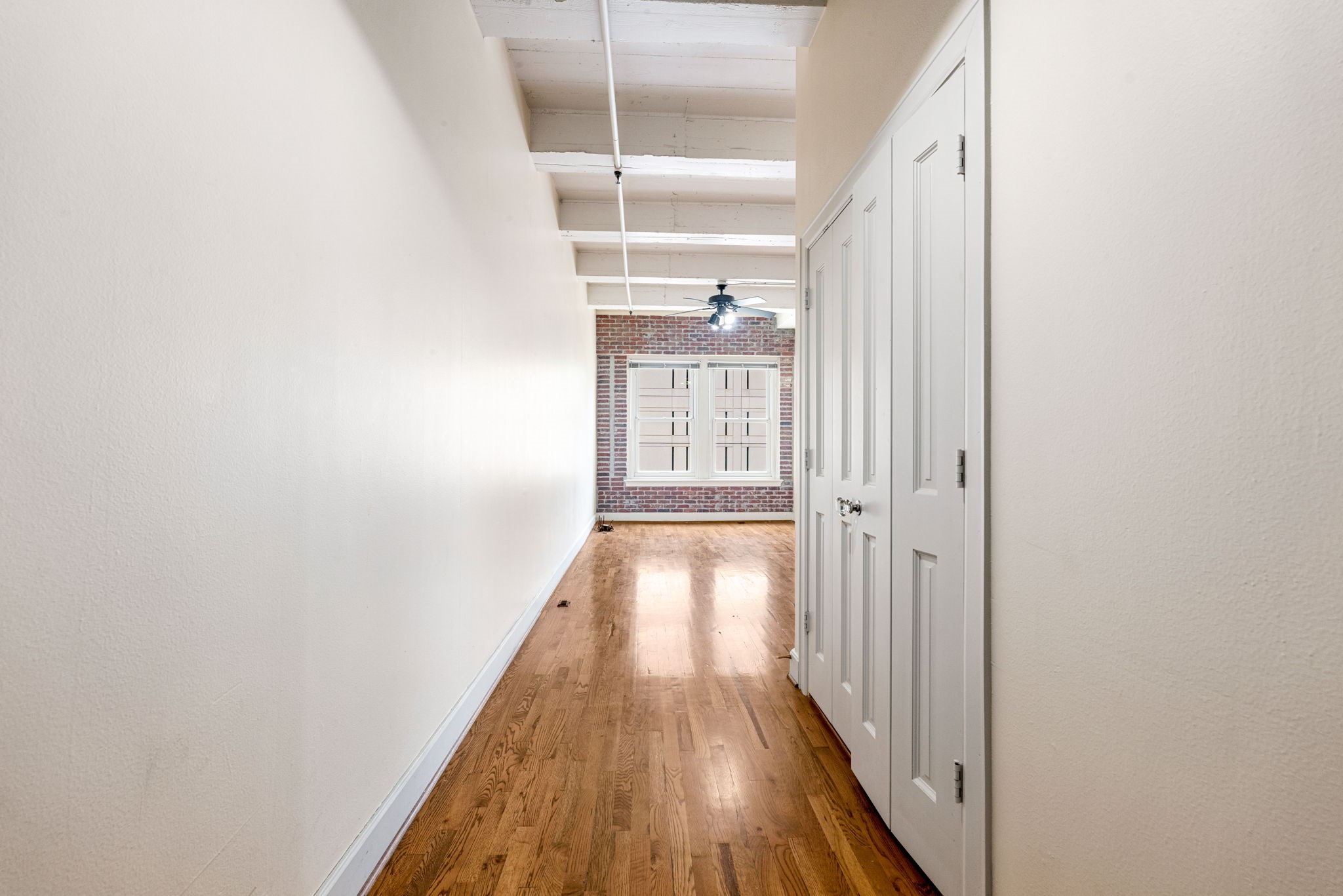 1120 Texas Street, Unit 7D Houston, TX 77002 - Photo 10 of 28 a view of a hallway with wooden floor and a window