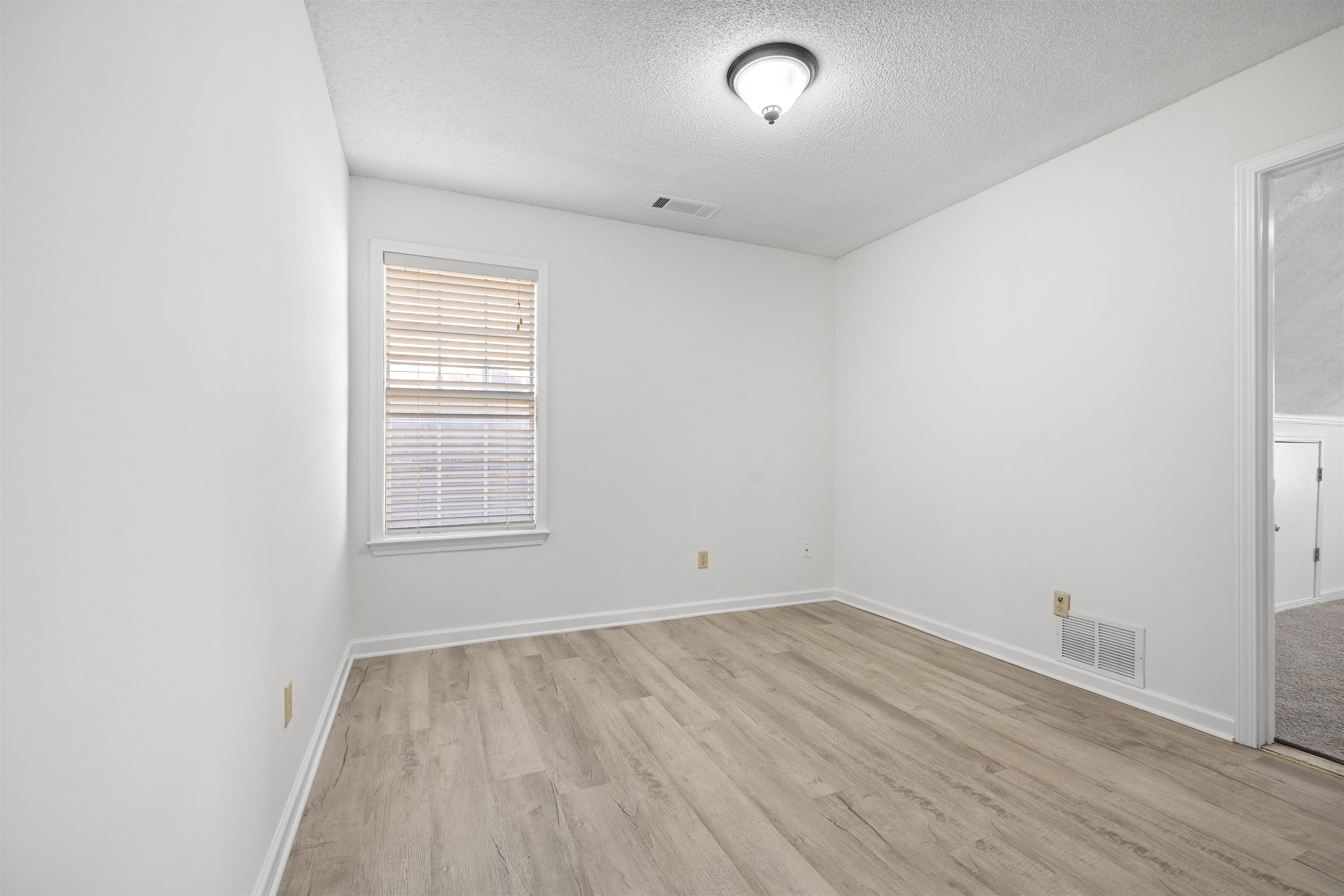 7361 Appling Ridge Drive Cordova, TN 38018 - Photo 26 of 31 Empty room featuring a textured ceiling and light wood finished floors