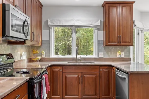 a kitchen with stainless steel appliances wooden cabinets and a stove top oven