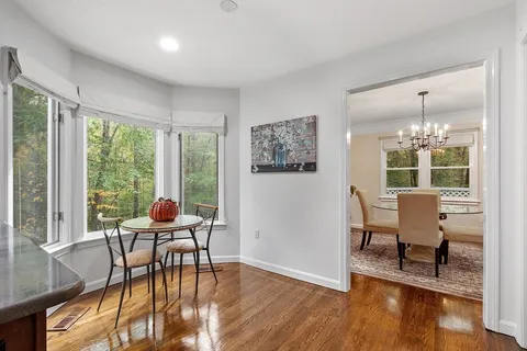 a dining room with furniture a chandelier and wooden floor