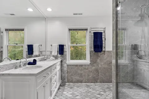 a bathroom with double vanity and a shower