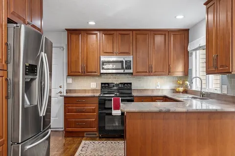 a kitchen with stainless steel appliances granite countertop a refrigerator stove and sink