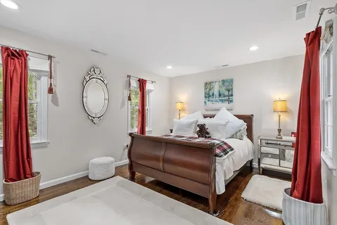 a bed room with a bed couch and a mirror