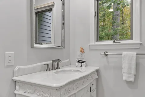 a bathroom with a granite countertop sink and a mirror