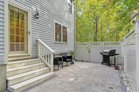 a view of a patio with table and chairs and wooden fence