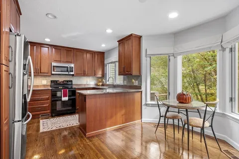 a kitchen with stainless steel appliances granite countertop a stove top oven a sink and a refrigerator