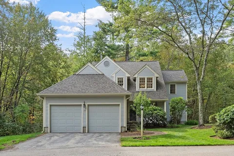 a sign of golf club on a wall under a tree
