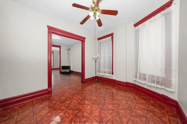 a view of a room with a ceiling fan and window