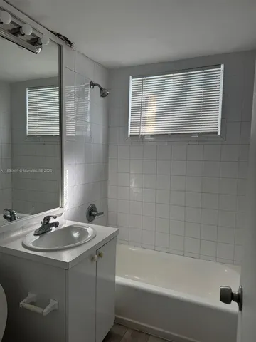 a bathroom with a sink vanity tub and a mirror