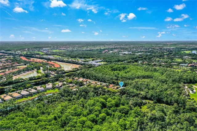 an aerial view of residential house with outdoor space and trees all around