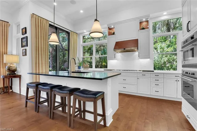 a kitchen with granite countertop a stove a table and chairs in it