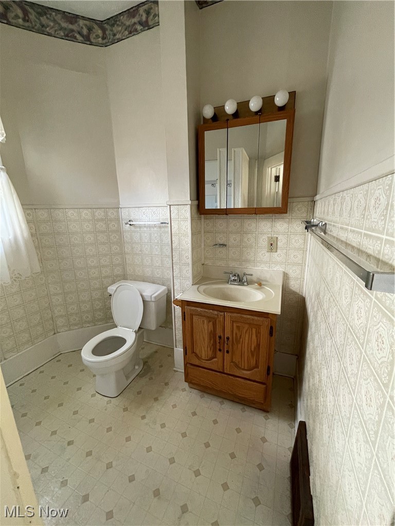1881 Manchester Road Akron, OH 44314 - Photo 18 of 31 Bathroom with vanity, a wainscoted wall, tile walls, and tile patterned floors