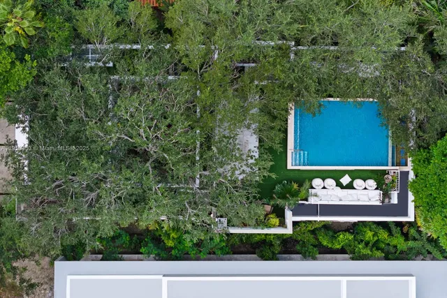 a living room with a floor to ceiling window and potted plants
