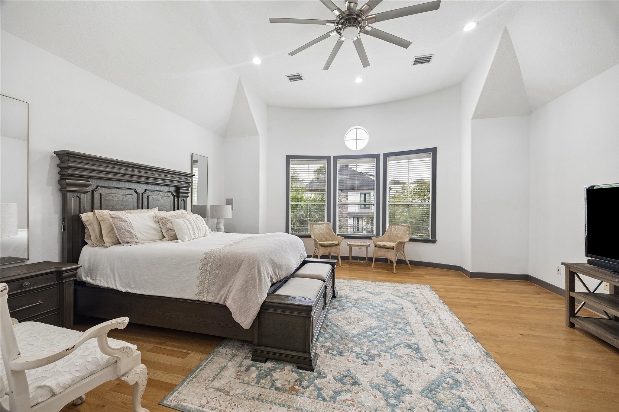 6406 Rodrigo Street, Unit B Houston, TX 77007 - Photo 17 of 27 Third floor primary bedroom with high ceilings, recessed lighting, and a modern style ceiling fan. Wood flooring and the windows provide natural light.