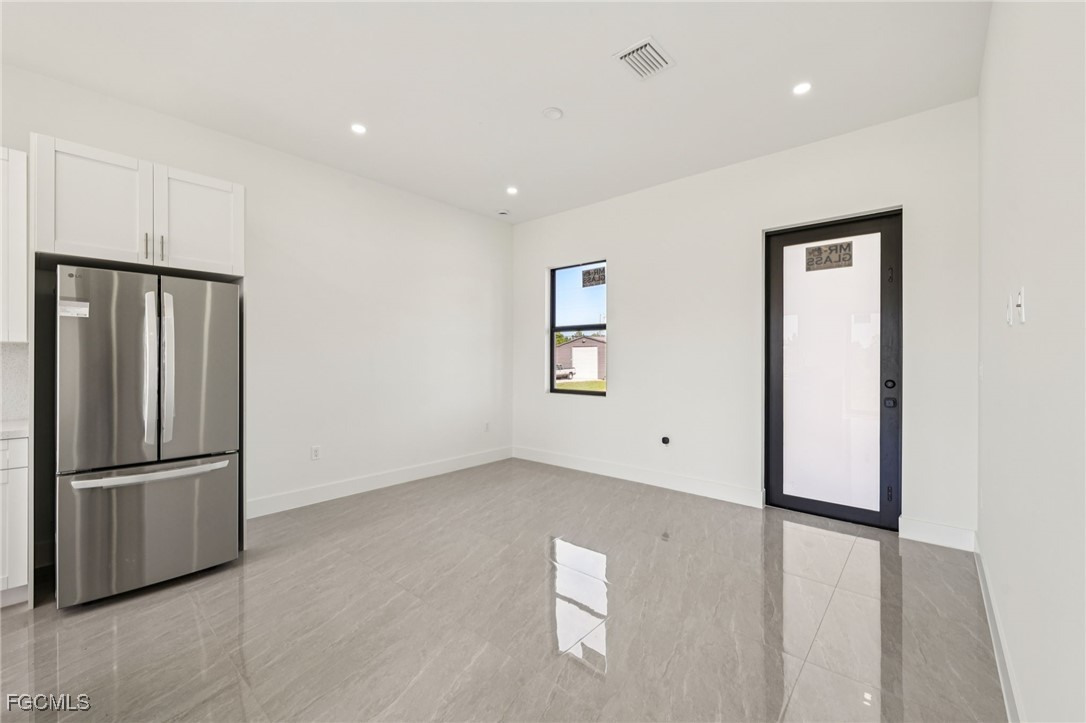 4402 East 19th Street Lehigh Acres, FL 33972 - Photo 14 of 31 a view of an empty room with wooden floor and a kitchen