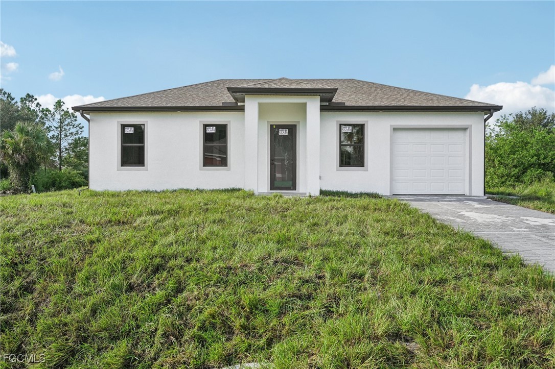 4402 East 19th Street Lehigh Acres, FL 33972 - Photo 2 of 31 a front view of house with yard and trees in the background
