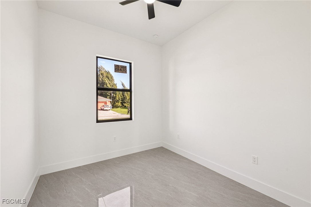 4402 East 19th Street Lehigh Acres, FL 33972 - Photo 26 of 31 an empty room with a window and a ceiling fan