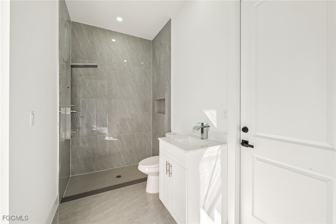 4402 East 19th Street Lehigh Acres, FL 33972 - Photo 31 of 31 a bathroom with a bathtub shower sink mirror and toilet