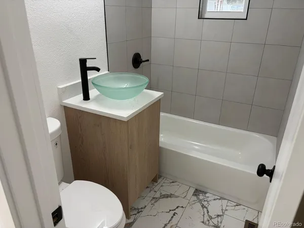 a bathroom with a sink a toilet and bathtub